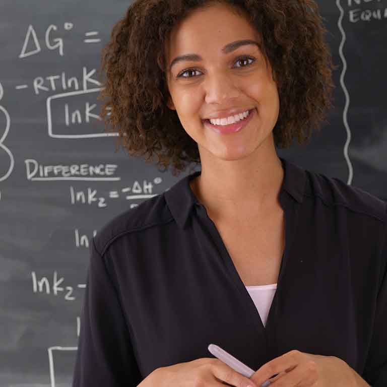 Teacher in front of chalk board