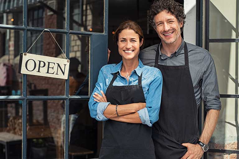 A woman and man in front of their business 