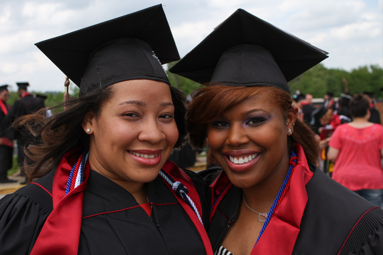 Two young women in IU stoles and honor cords take a quick pic together after the ceremony