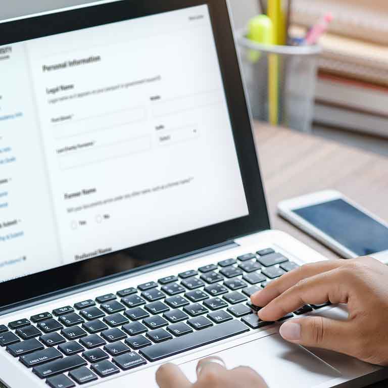 Person completing an IU Southeast college application on a laptop